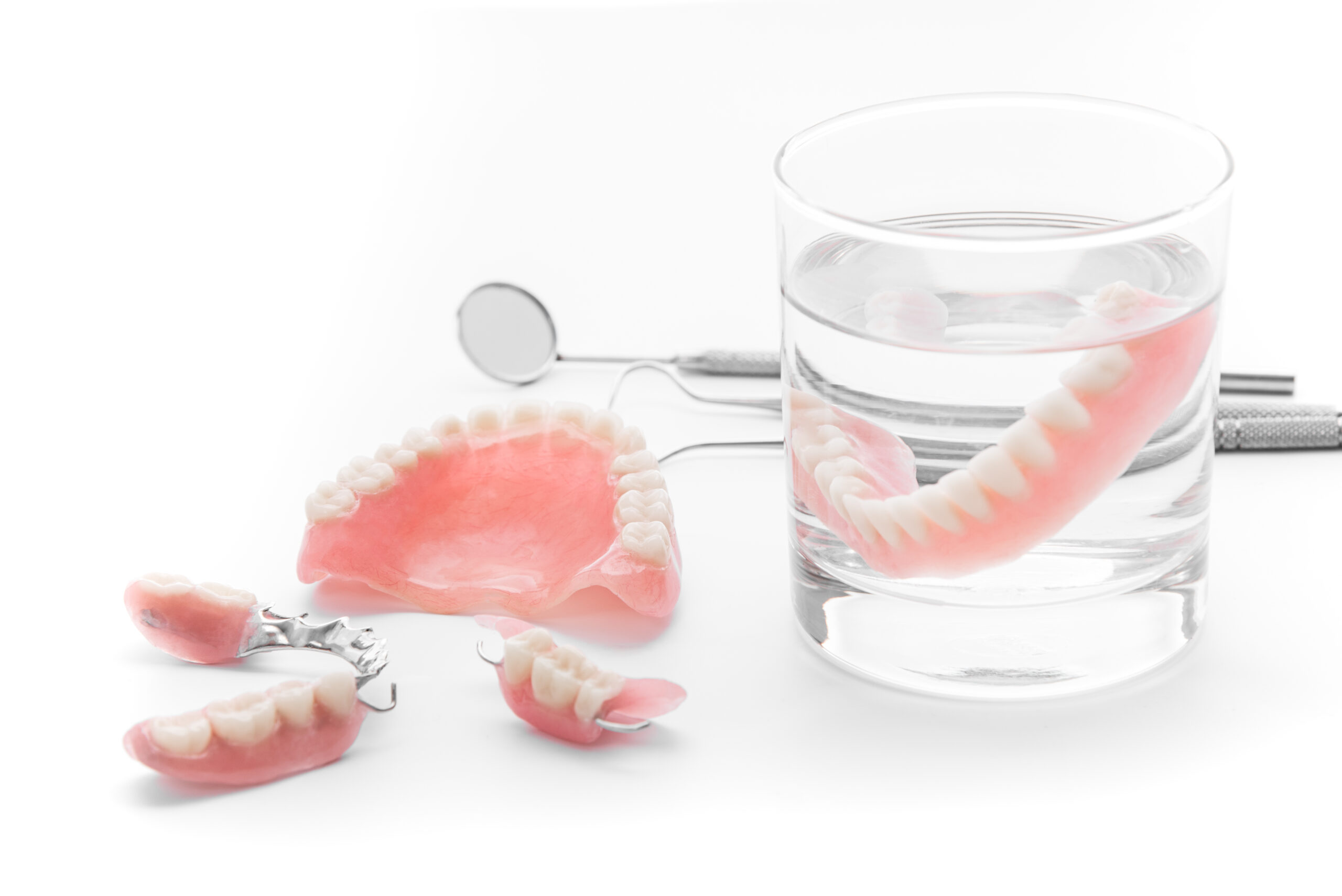 Set,Of,Denture,In,Glass,Of,Water,And,Tools,On